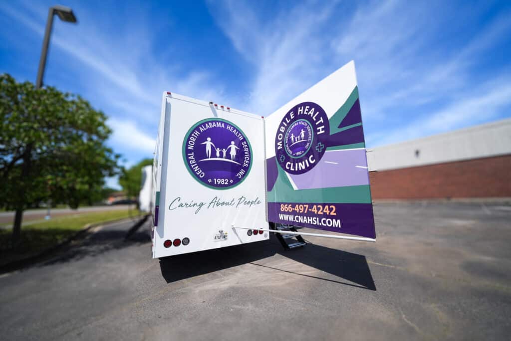 Health Mobile Unit in action, rear facing view with logo and contact information.