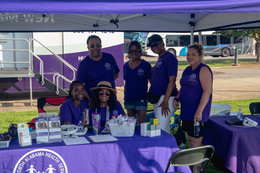 Central North Alabama Health Services, Inc. Staff are groped in photo smiling during the Community Fun & Wellness Block Party In Huntsville, Alabama.